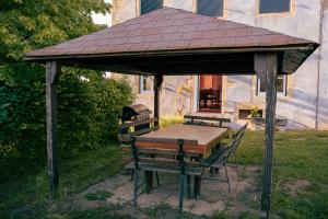 a picnic shelter with a table and a grill at Le Champ Du Possible - Grande maison de caractère rénové pour famille et groupe in Uxeau