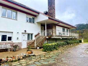 a white house with a porch and a balcony at Villa Eiros in Belandres