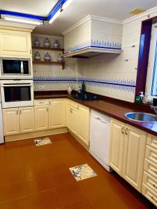 a kitchen with white cabinets and a sink at Villa Eiros in Belandres +15 photos