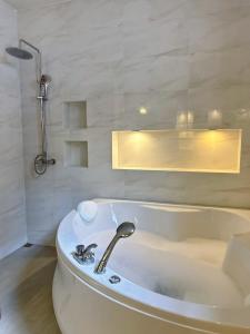 W łazience znajduje się biała wanna i umywalka. w obiekcie Luekpanee pool villa pranburi w mieście Ban Nong Ban Kao