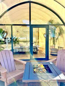 una habitación con 2 sillas y una mesa con un plato de comida en The Retreat and Domes, en Fredericksburg