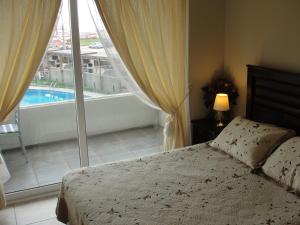 a bedroom with a bed and a view of a pool at Mirador El Faro in La Serena