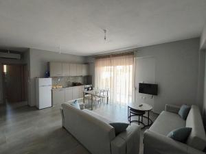 a living room with a couch and a table and a kitchen at Irina's Apartment 3 in Psakoudia