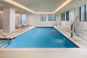 雷斯顿AC Hotel by Marriott Reston的蓝色的游泳池,位于酒店客房内