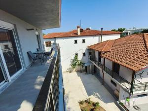 an apartment balcony with two chairs and a roof at Irina's Apartment 3 in Psakoudia
