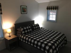a bedroom with a bed with a black and white checkered blanket at Young Cottage in Norway