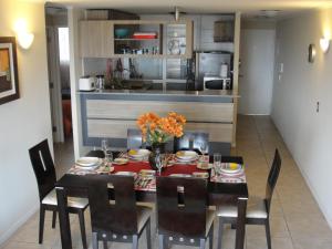 cocina y comedor con mesa y sillas en Mirador El Faro, en La Serena
