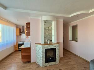 a living room with a fireplace and a kitchen at Kesk Central Apartment in Valga