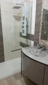 a bathroom with a sink and a glass shower at Copernico casa vacanze, nel centro di Lecce in Lecce