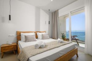a bedroom with a large bed with a view of the ocean at Pelagos Home in Kalamaki Heraklion