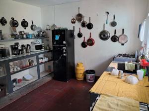eine Küche mit Töpfen und Pfannen, die an der Wand hängen in der Unterkunft Casa 25 in Nanastepeque