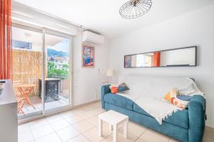a living room with a blue couch and a balcony at Studio port de Nice Clim Balcon in Nice