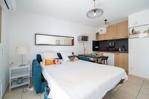 a bedroom with a large bed and a kitchen at Studio port de Nice Clim Balcon in Nice