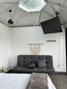 a couch in a living room with a ceiling at Rocks Glamping - Guatapé, El Peñol in El Peñol