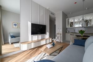 a living room with a couch and a tv at Nad zatoką Ukiel apartamenty przy jeziorze in Olsztyn