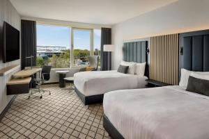 a hotel room with two beds and a desk at Courtyard by Marriott Hannover Maschsee in Hannover +33 photos