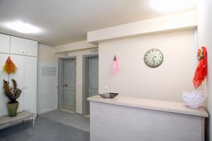 ein Wohnzimmer mit einer Uhr an der Wand in der Unterkunft Niriides in Lefkada Town