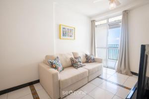 a living room with a couch and a window at Aptos completos na melhor localização e a passos do mar de Guarapari - STP in Guarapari