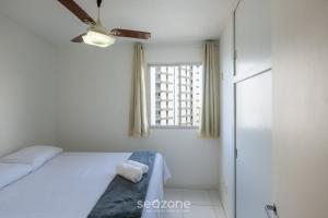 a bedroom with a bed and a window at Aptos completos na melhor localização e a passos do mar de Guarapari - STP in Guarapari