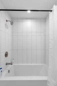 ノースバンクーバーにあるModern North Shore Nest with Balconyの白いタイル張りの壁、バスルーム(バスタブ付) +21枚の写真