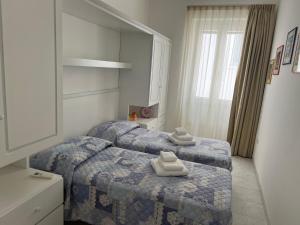 two beds in a hotel room with towels on them at casa Pepi in Olbia