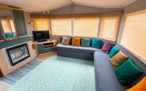 a living room with a couch and a tv at WW213 - 4 bed, Parkdean Camber in Camber
