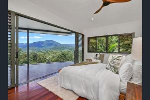 Edge HillにあるPlanchonella Rainforest Pavilionの大きなベッドと大きな窓のある寝室 +18枚の写真