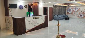 a lobby with a reception counter and a waiting room at Crown Suites in Dhārwād