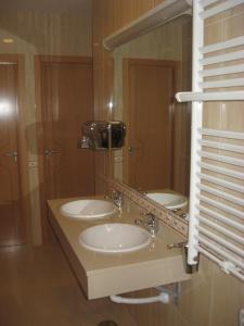 a bathroom with two sinks and a mirror at Hotel Pattaya in Mocejón