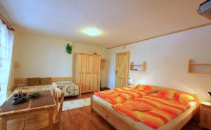 a bedroom with a large bed and a table at Studia Aurora in Demanovska Dolina