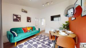 a living room with a green couch and a table at Central & Modern - Fast WIFI - 5 Min to Centre in Cardiff