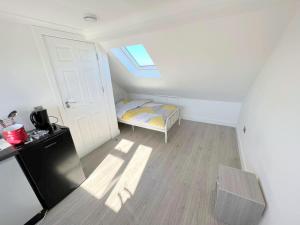 HackbridgeにあるHuge 7-bedroom House in Croydonのベッドと窓のある小さな部屋 +20枚の写真