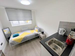 HackbridgeにあるHuge 7-bedroom House in Croydonのベッドと洗面台のある小さな寝室