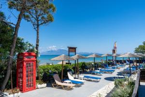 a row of beach chairs and a red phone booth at Oasis Beachfront Studios & Apartments, by ZanteWize in Alikanas