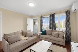 un soggiorno con due divani e una finestra di Rangeway Rescue - Older 3BR Home a Geraldton