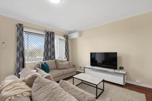 un soggiorno con divano e TV a schermo piatto di Rangeway Rescue - Older 3BR Home a Geraldton