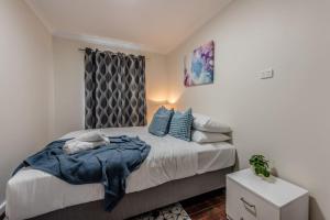 una camera da letto con un letto con cuscini blu di Rangeway Rescue - Older 3BR Home a Geraldton