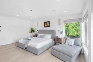 una camera da letto con un letto, un divano e una finestra di 2505 Edgemont Blvd.- Anupoju a North Vancouver Altre 59 foto