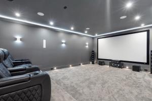 una sala cinema con uno schermo bianco e un divano di 2505 Edgemont Blvd.- Anupoju a North Vancouver