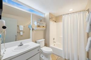 シダー・キーにあるBeach Comber 215 at Cedar Cove Condosの白いトイレと洗面台のあるバスルーム +11枚の写真