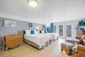 a bedroom with two beds and a living room at Stay-Seas Hideaway 214 at Cedar Cove Condos in Cedar Key