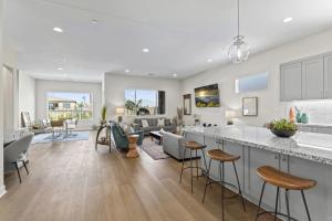 a kitchen and living room with a counter and chairs at Gallery at Indian Palms Walk to the Festivals Pool Hot Tub Pickleball in Indio