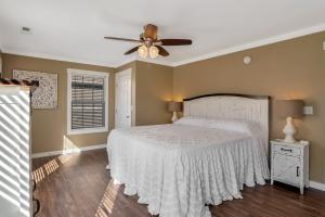 een slaapkamer met een bed en een plafondventilator bij Travelers Fairview Haven in Fairview