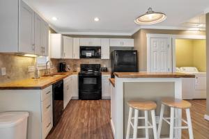 een keuken met witte kasten en zwarte apparaten bij Travelers Fairview Haven in Fairview