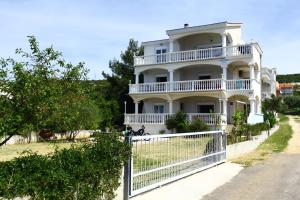 a white house with a fence in front of it at Apartments Natali in Sveti Petar