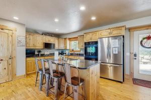 eine Küche mit Holzschränken und eine Insel mit Barhockern in der Unterkunft Timberland in Garden City