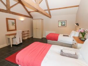 a bedroom with two beds and a desk in a room at Gallow Law Cottage in Greenhaugh