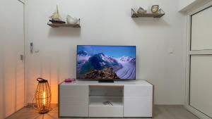 a tv sitting on a cabinet in a living room at Bungalow Carioca Vue mer piscine privée au calme in Le Robert