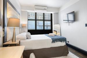 a bedroom with a large bed and a window at PH2 Studio At The Mansfield in New York +5 photos