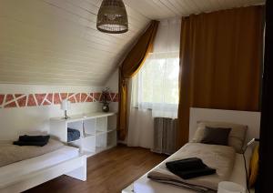 a bedroom with two beds and a window at Pelso d'Oro apartmanház in Balatonföldvár +28 photos